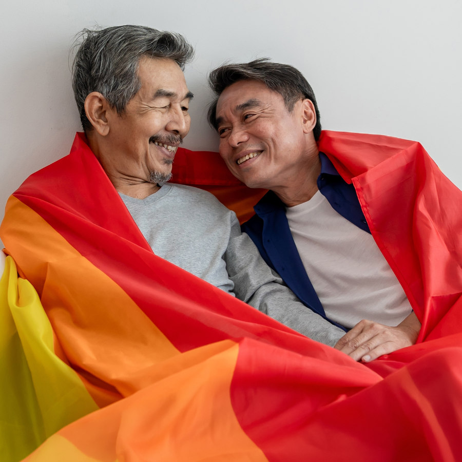 Deux personnes portant un chandail avec le drapeau de la fierté